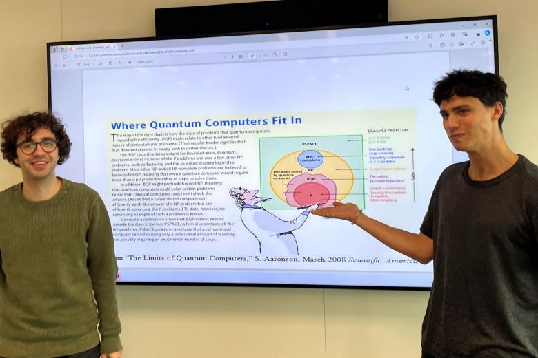 Daniel Marcon (left) and Andy Caen in front of a whiteboard explaining quantum computing