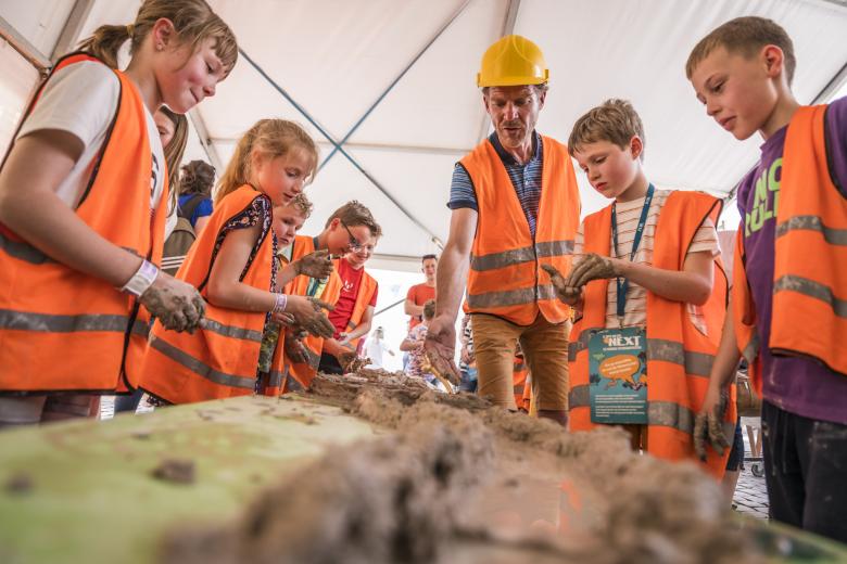 Kinderen met veiligheidsvestjes krijgen uitleg op Expeditie Next