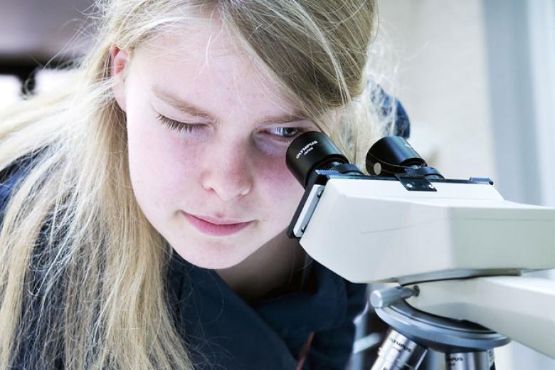 Girl looking through microscope