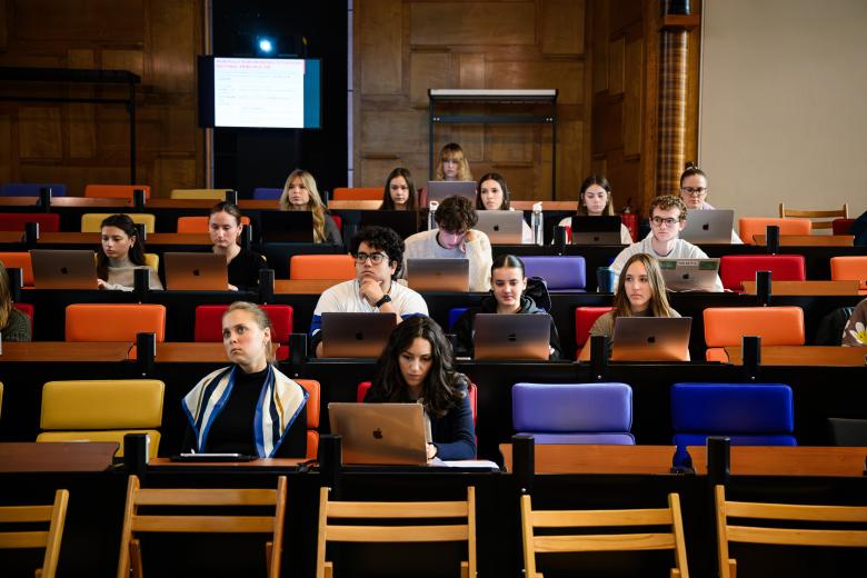Studenten volgen college in de Statenzaal van de faculteit en maken aantekeningen op hun laptops.