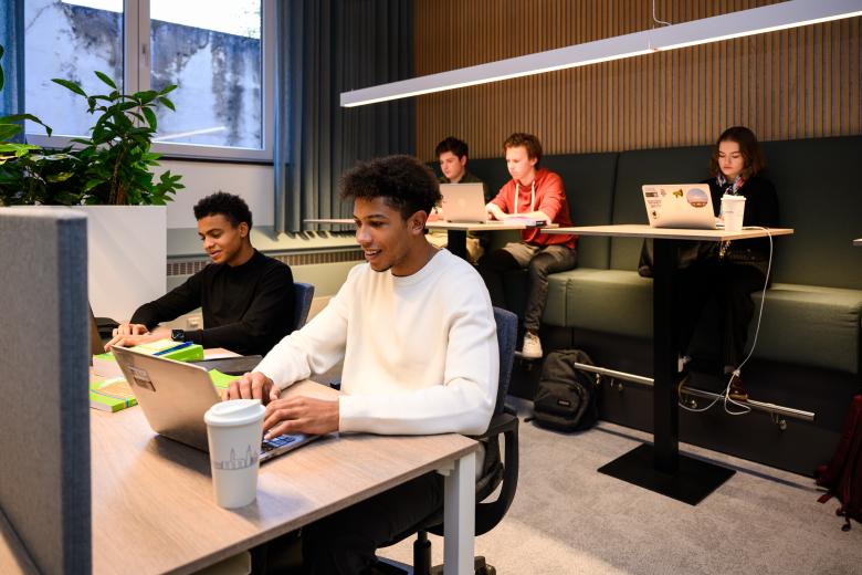 Studenten werken individueel en in stilte aan hun opdrachten in de learning space van de faculteit.