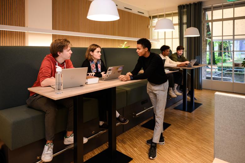 Students are discussing at a high study table in the faculty’s learning space, overlooking the inner courtyard.