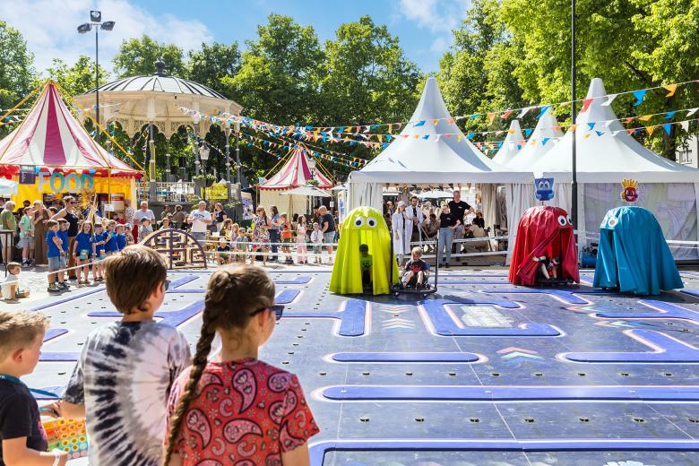 Een levensgrote Pacman-achtige game waar kinderen in hartvormige wagentjes rondrijden op een baan op Expeditie Next.
