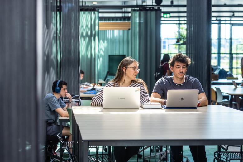 Two students working with their laptop in study space