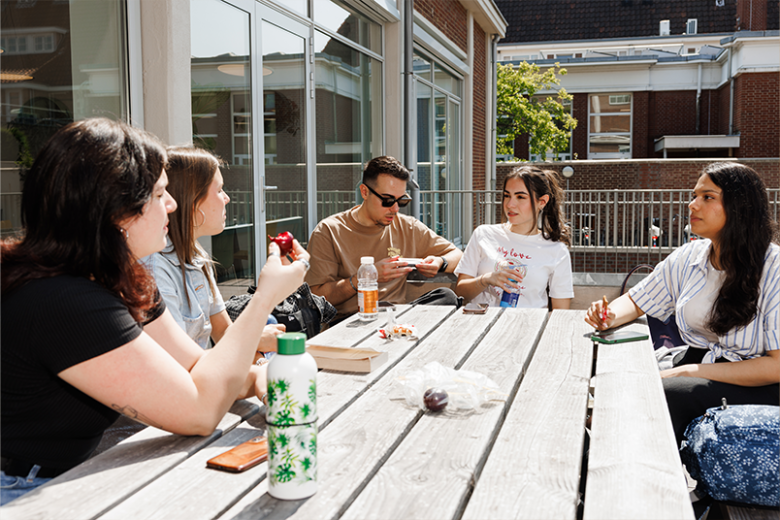 Students chilling out outside at a picknick table