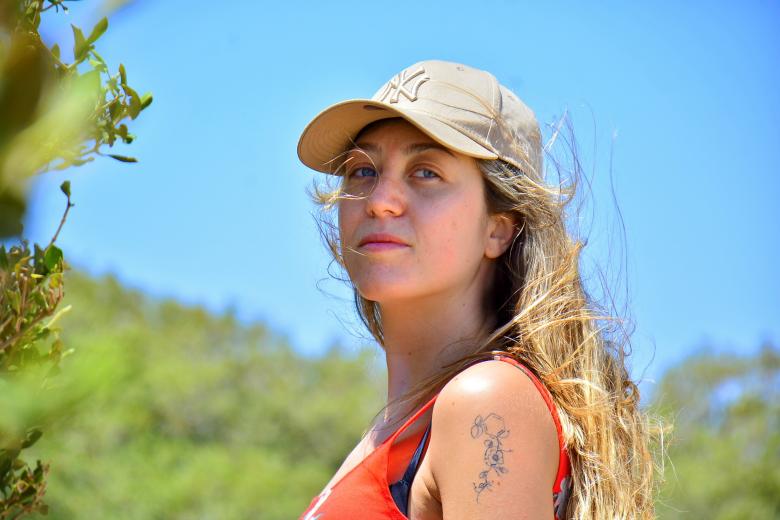 Margaux Frigoli wearing a cap and showing the strawberry related tattoo on het shoulder