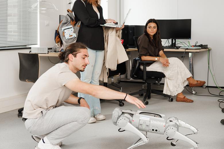Guy playing with robot dog