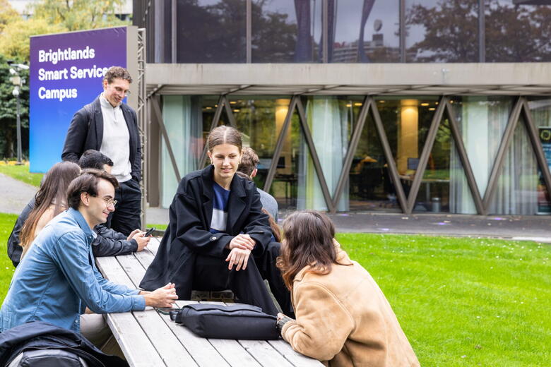 Students sitting in front of Brightlands Smart Services building