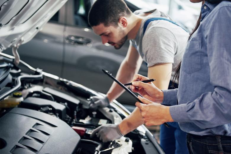 Two young car mechanics at work