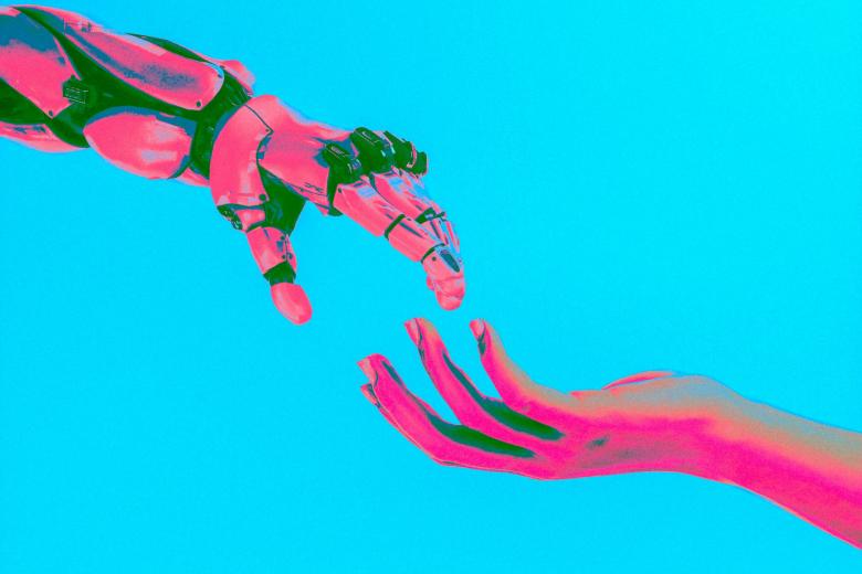 A robot hand and a human hand reaching for one another