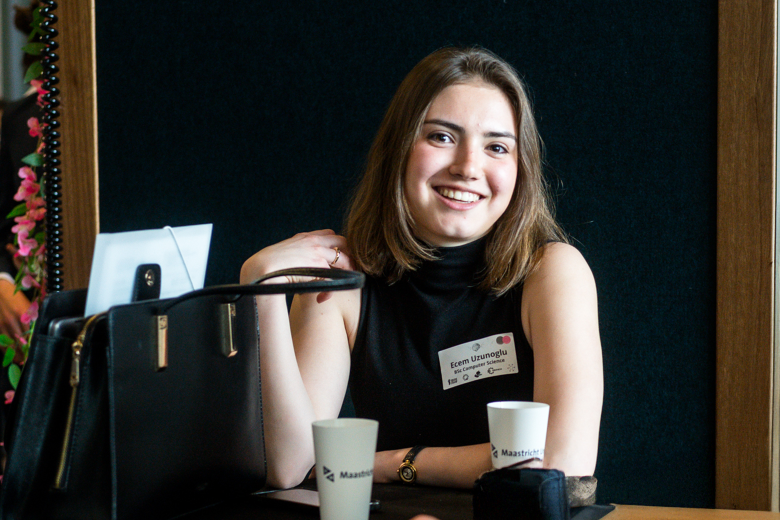 Young woman smiling in front of black wall