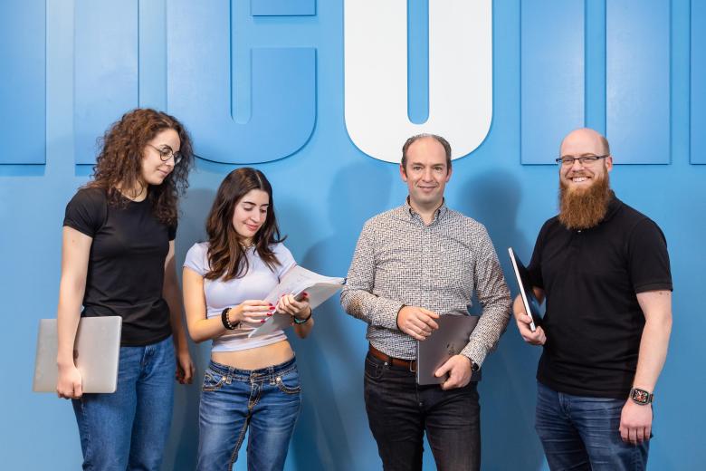 students and staff in front of NLcom logo