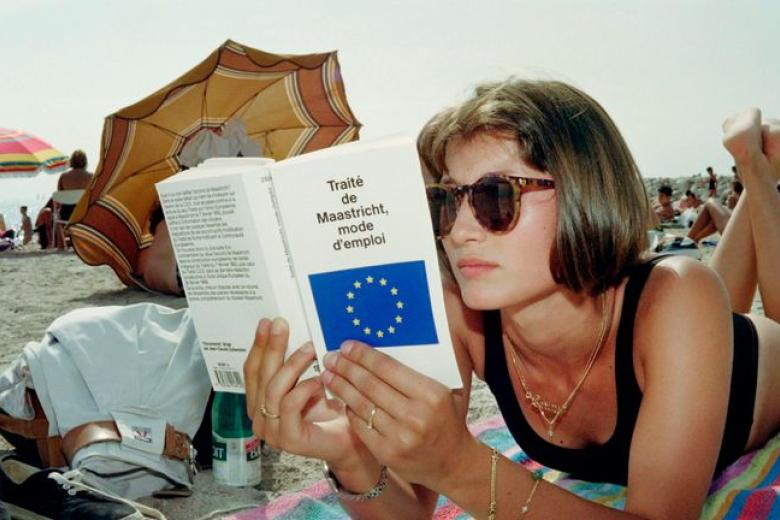 Woman on beach reading the Maastricht Treaty