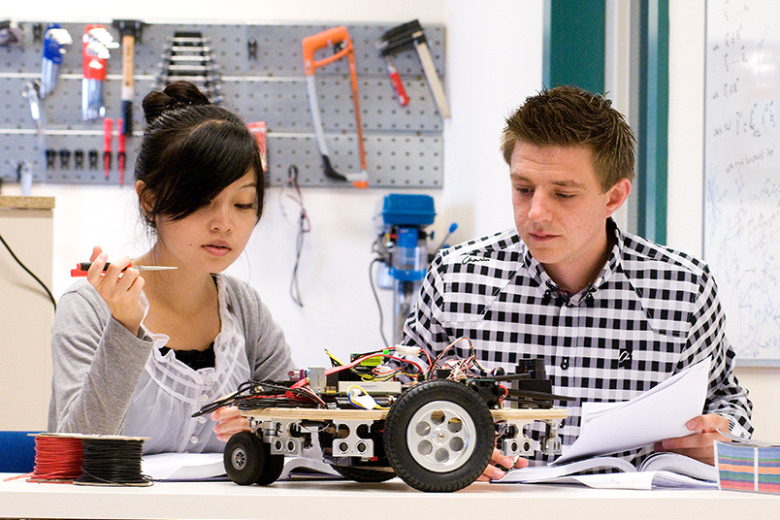 Twee studenten werken aan robot autootje