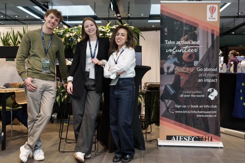A guy and two girls smiling at career fair