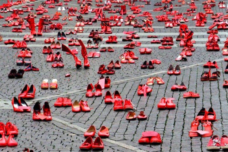 Red women's shoes on a square as a protest against femicide