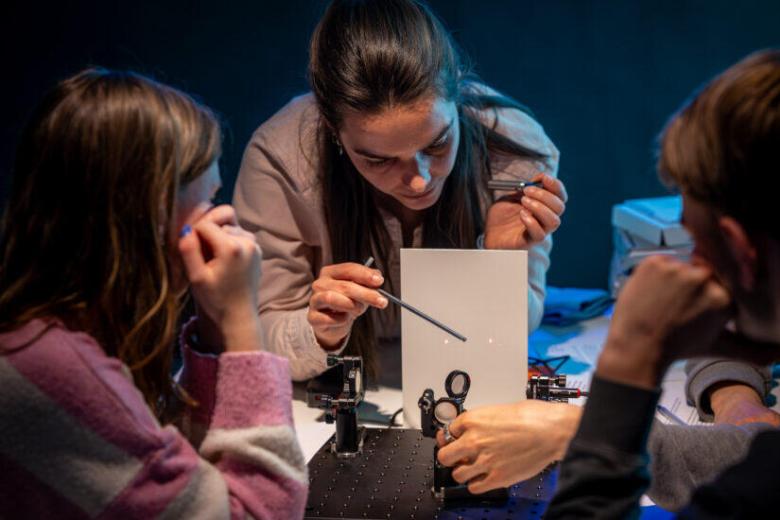 Emma Prins explaining a laser experiment to high school students