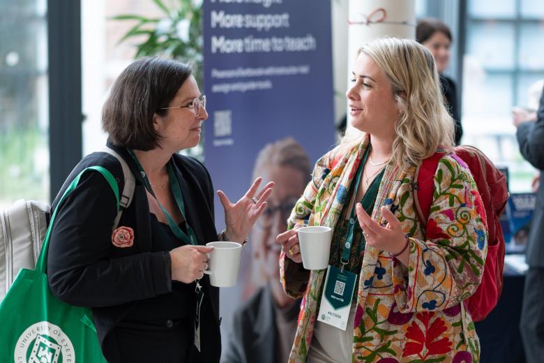 two participants at a conference talking over a cup of coffee