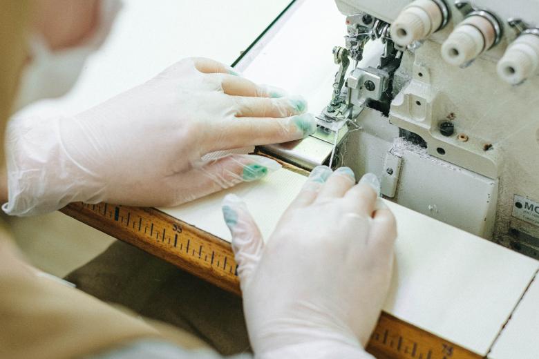 Person sewing fabric with sewing machine